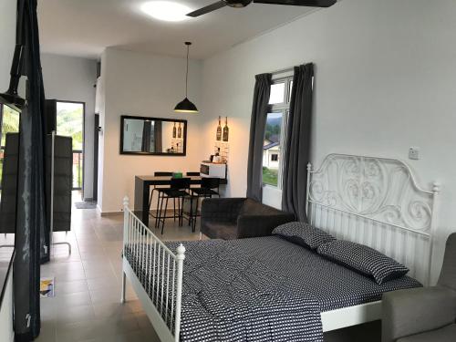 a bedroom with a bed and a living room at Rumah Sawah Homestay Pasir Puteh in Pasir Puteh