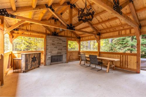 a large screened in porch with a fireplace and a wooden ceiling at The Magnificent 7 in Columbia Falls