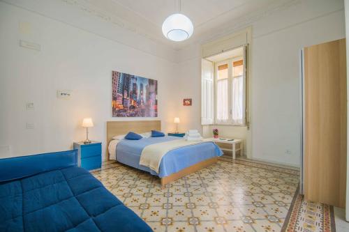Un dormitorio con una cama azul y un sofá. en Bed&Breakfast Salerno, en Salerno