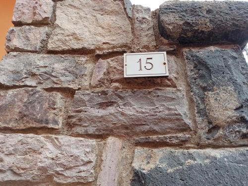a stone wall with a clock on it at Fontana Nuova in Sardara