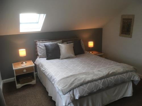 a bedroom with a large bed with two night stands at Maesnewydd Cottage in Welshpool