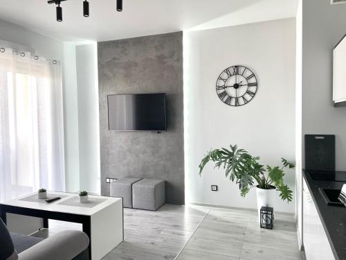 uma sala de estar com uma mesa e um relógio na parede em Ach, To Tu- Apartament Łańcut em Lańcut