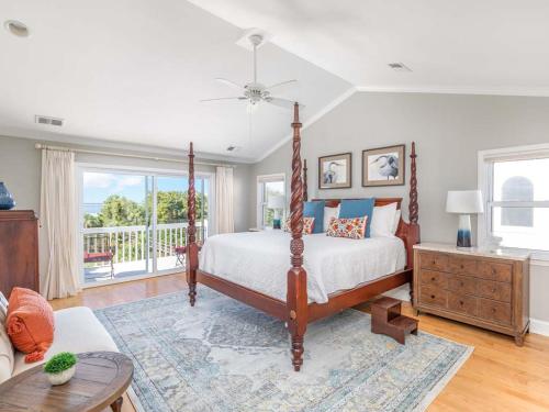 een slaapkamer met een hemelbed en een balkon bij A Salty Senorita in Tybee Island