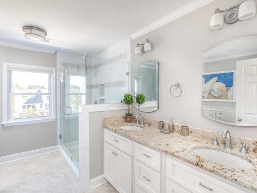 een witte badkamer met 2 wastafels en een douche bij A Salty Senorita in Tybee Island