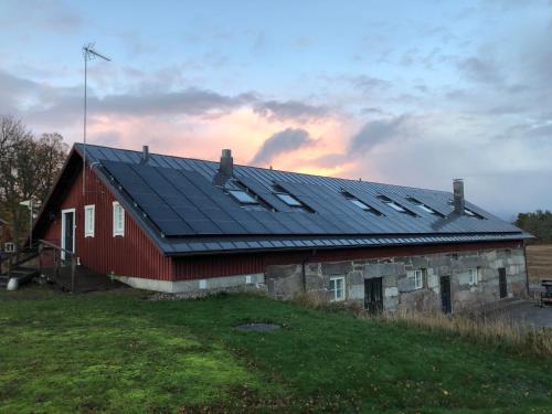 een rode schuur met zonnepanelen op het dak bij Hotel Stallbacken Nagu in Nauvo