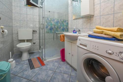 ein Badezimmer mit einer Waschmaschine und einem Waschbecken in der Unterkunft Apartment Vlatka in Rogoznica
