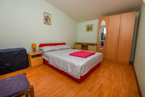 una camera da letto con un letto e un asciugamano rosso sopra di Apartment Vlatka a Rogoznica (Rogosnizza)