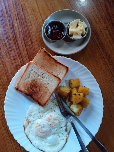 a plate of food with eggs and toast and potatoes at Crocodile Safari Camp in Chitwan