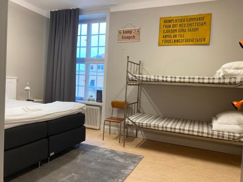 a bedroom with two bunk beds and a window at Livgrenadjärmässen Hotell-Fest-Konferens in Linköping