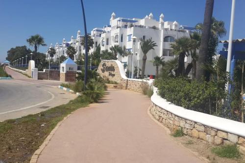 a walkway in front of a large white building at Superbe appart 3pieces a sania plage MARINA SMIR in M'diq