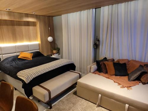 a bedroom with a bed and a couch in it at Hotel Bourbon Ibirapuera Suite 5 estrelas Moema in São Paulo