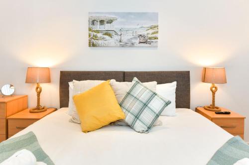 a bedroom with a white bed with two lamps at Just Stay Wales - Meridian Wharf, Marina View - 2 Bed Apartment in Swansea