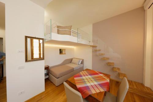 uma sala de estar com uma escada e uma mesa em Siena UpTown - Sabrina's Cozy Apartment em Siena