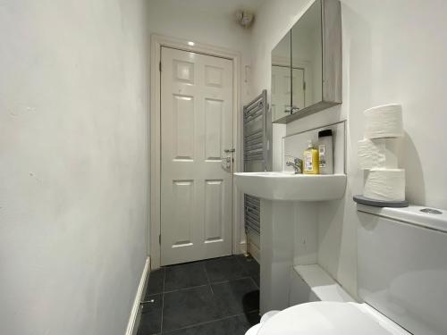 a white bathroom with a sink and a toilet at Nice Living Serviced Accommodations 3 in Coventry