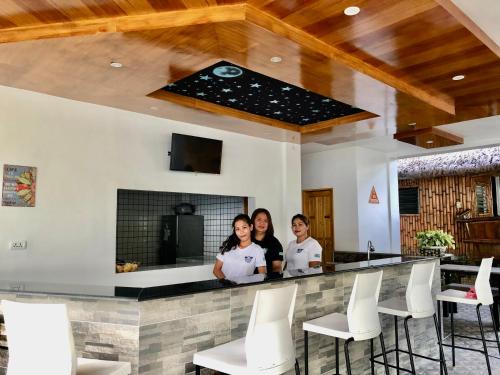 GEM Crystal Water Resort في مدينة دافاو: ثلاث نساء واقفات في بار في مطعم
