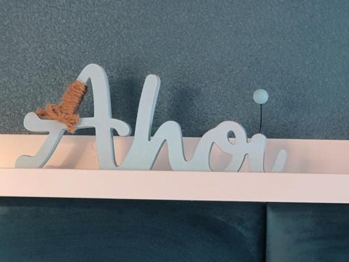 a white sign that says akarma on a wall at Haus Achtern Diek in erster Reihe am Meer in Fehmarn