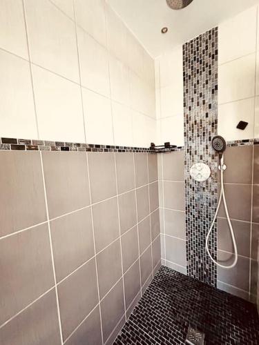 a bathroom with a shower with a black and white tiles at Entre Nous in Vironchaux