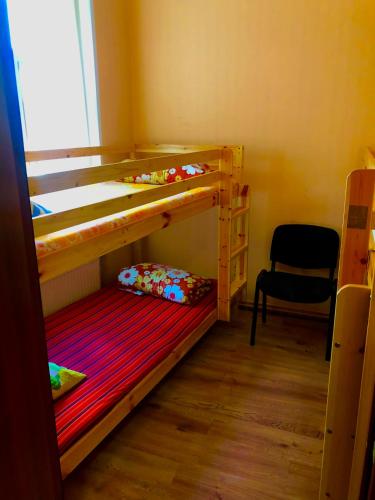 ein Zimmer mit Etagenbetten, zwei Etagenbetten und einem Stuhl in der Unterkunft BalticApart Riga in Riga