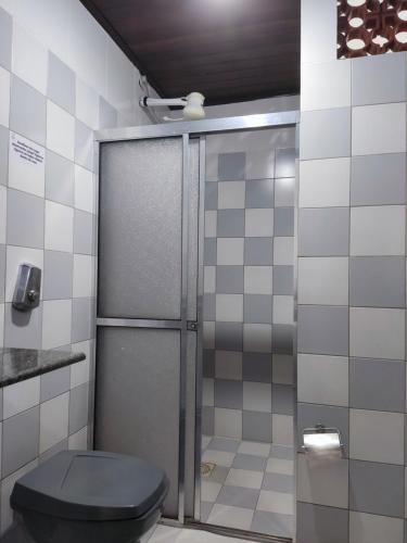 a bathroom with a shower with a blue toilet at POUSADA PRAIAMAR in Prado