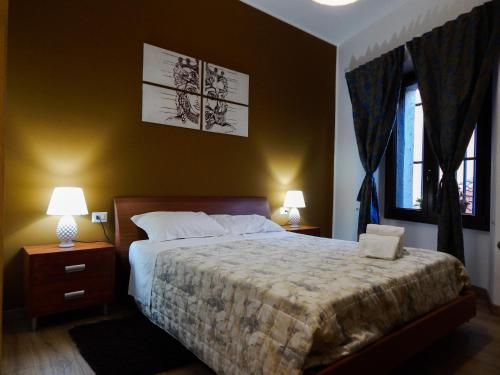 a bedroom with a bed with two night stands and two lamps at Camurria in Piazza Armerina