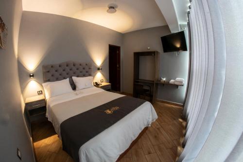 una camera d'albergo con un grande letto e una TV di Hotel Las Terrazas De Caral a Barranca