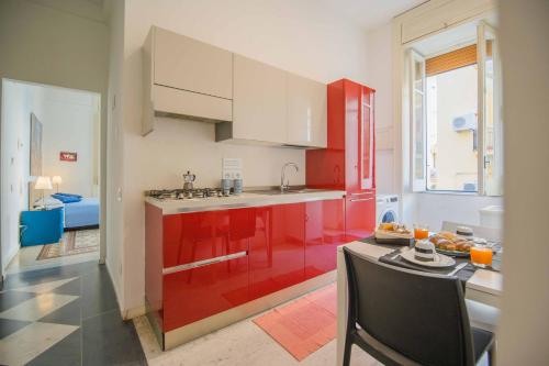 Una cocina con gabinetes rojos y una mesa en una habitación. en Bed&Breakfast Salerno, en Salerno