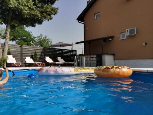 a swimming pool with two inflatable objects in the water at Odmaraliste Kod Miće Apartman 3 in Krušar