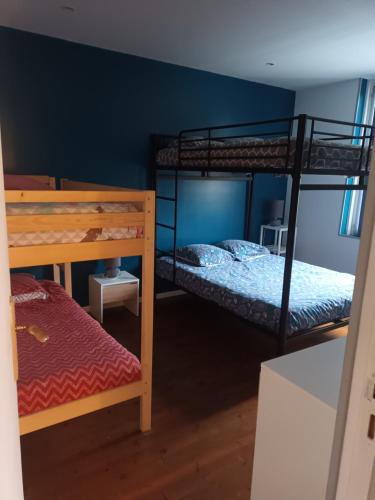 a bedroom with two bunk beds and a bench at LA MEDINA in La Fère