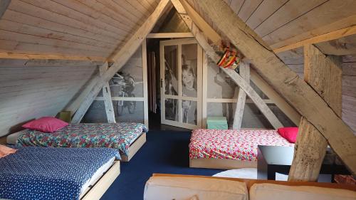 a attic room with two beds and a couch at Miniloft Abel Abri in Zingem