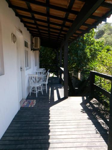a wooden porch with a table and chairs on it at Deck de Búzios in Búzios