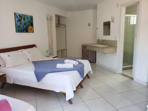 ein Schlafzimmer mit einem Bett und einem Waschbecken darin in der Unterkunft Deck de Búzios in Búzios