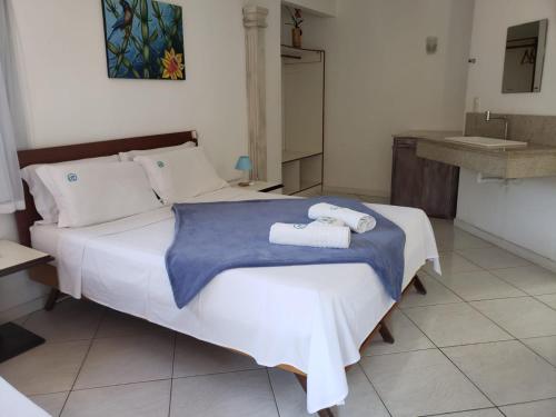 a bedroom with a bed with two towels on it at Deck de Búzios in Búzios