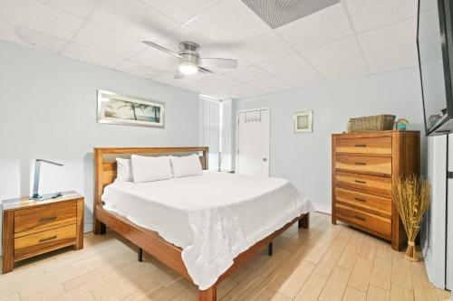a bedroom with a bed and a wooden dresser at Sans Souci 407 in Pensacola Beach