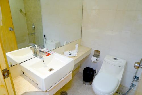 uma casa de banho branca com um lavatório e um WC em Keyonn Hotels & Resorts em Amritsar