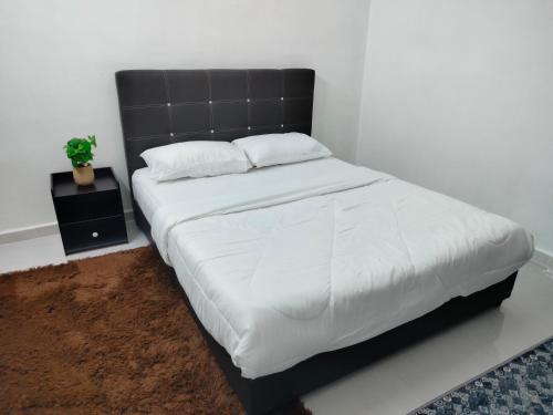 a bedroom with a large bed with a black headboard at MyHomestay07 in Kangar