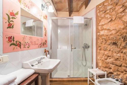 a bathroom with a shower and a sink and a toilet at Lletreres in Llubí