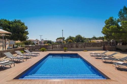 a swimming pool with chaise lounge chairs and a swimming poolvisor at Anglesos in Can Picafort