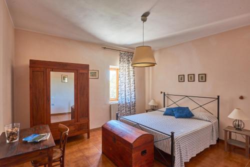 a bedroom with a bed and a table and a desk at Agriturismo Tesorino in Massa Marittima