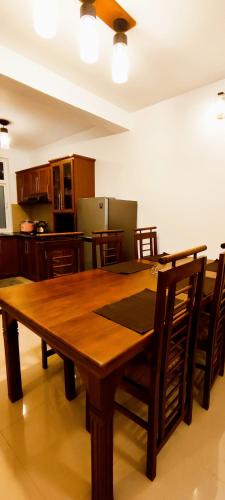 a wooden table and chairs in a kitchen at Moon Plains Luxury Apartments in Nuwara Eliya