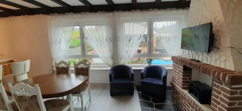 a living room with a dining room table and a television at Blue Lagoon in Nehren
