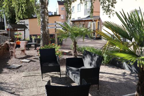 een groep stoelen en planten op een binnenplaats bij Hotel Martz in Pirmasens