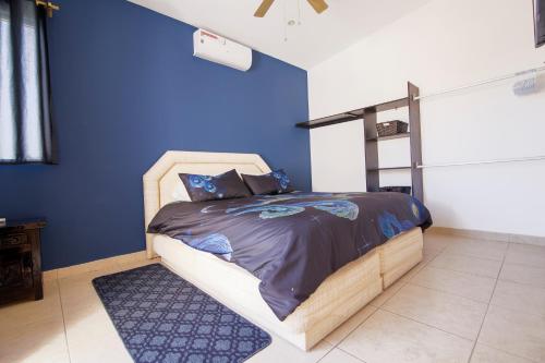 1 dormitorio con 1 cama con pared azul en Casa Robyn, en Cabo San Lucas