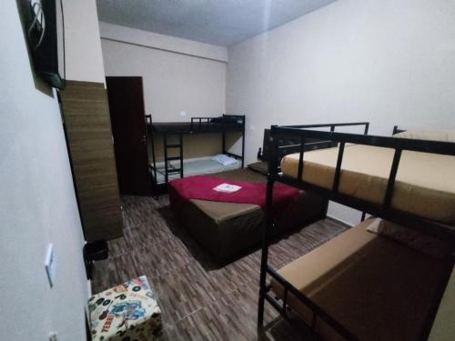 a room with two beds and a bunk bed at Hostel Aeroporto in Guarulhos