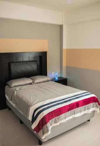 a bedroom with a large bed with a black headboard at Departamento Orellana 1 in Chetumal