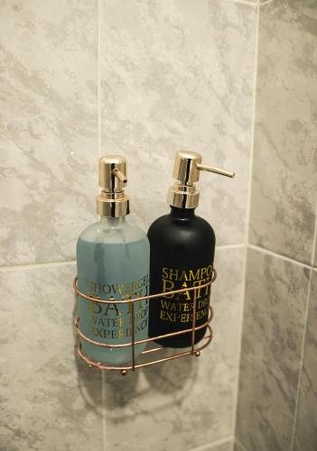 two bottles of soap in a rack in a shower at Departamento Orellana 1 in Chetumal
