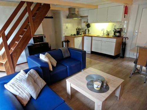 sala de estar con sofá azul y mesa en Huuske 086 en Simpelveld