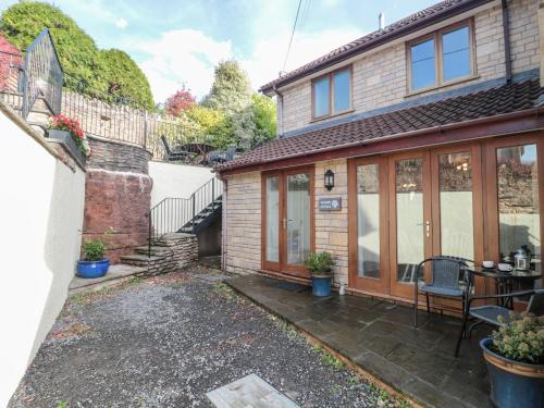 a brick house with a patio and a table at Quarry Cottage in Cheddar