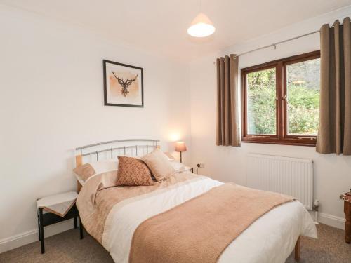 1 dormitorio con cama y ventana en Quarry Cottage, en Cheddar