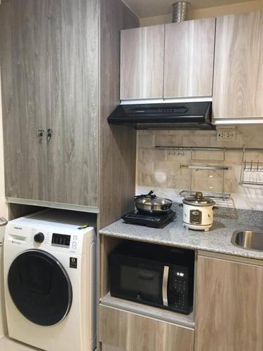 a small kitchen with a microwave and a stove at Condo near Ayala Cebu City w Wifi Balcony in Cebu City