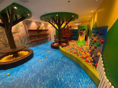a childrens play room with a water slide and trees at Condo near Ayala Cebu City w Wifi Balcony in Cebu City